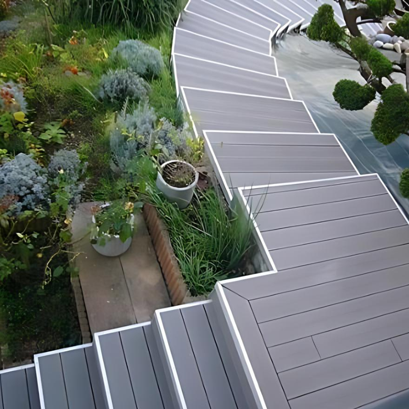 Escalier tournant en lames composite gris anthracite, avec nez de marche en aluminium pour une finition élégante.